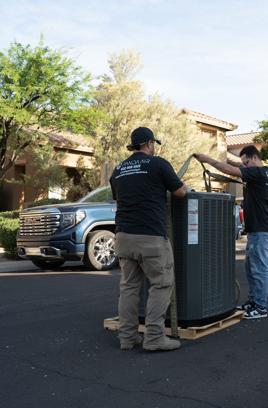 Crane truck and a new condensing unit rigged on a pallet in a driveway