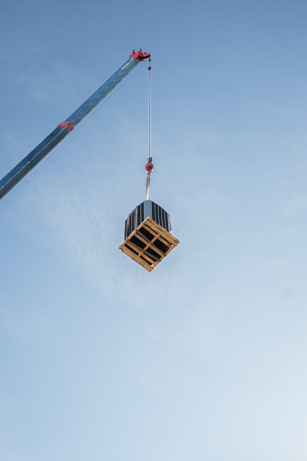 Crated equipment hanging from a crane boom