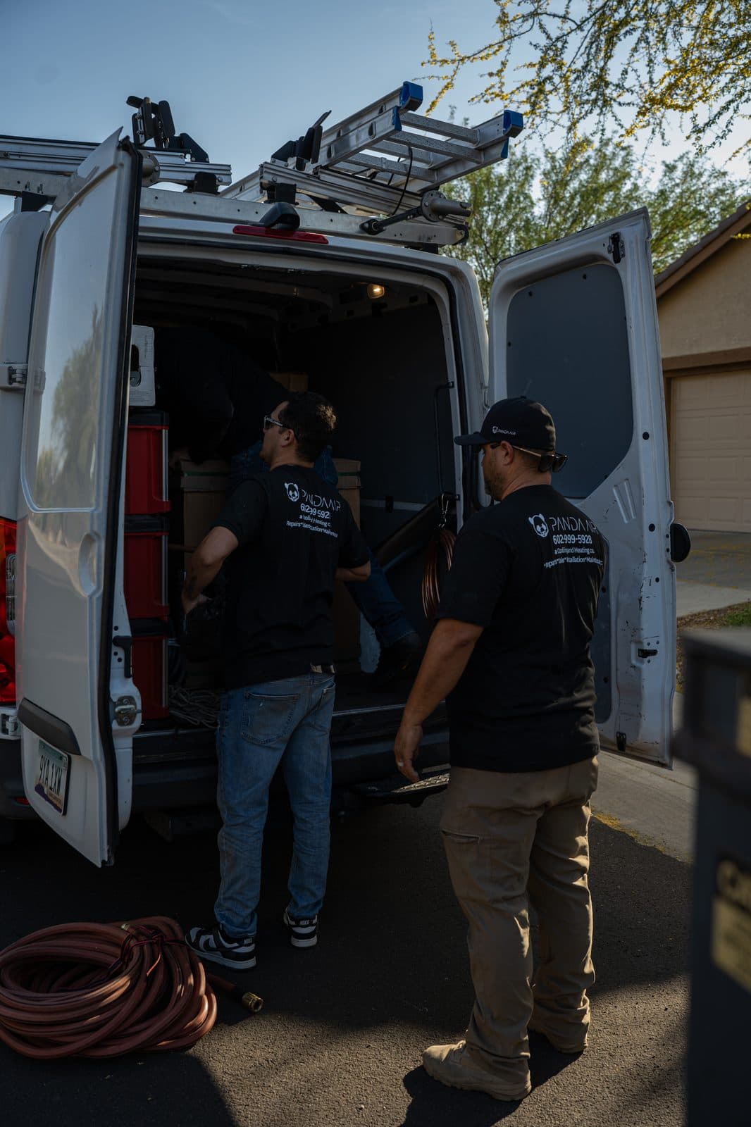 Two technicians unloading equipment from the service van